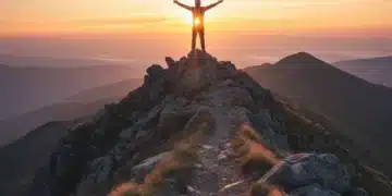 Person on mountain peak, symbolizing breakthrough and overcoming limiting beliefs.